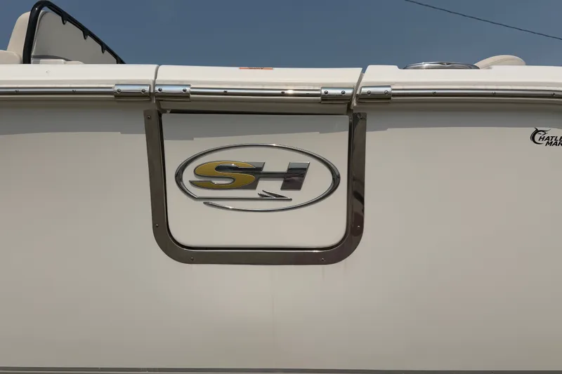 Slide: The Image of 2024 Sea Hunt Ultra 275 SE boat logo on white hull under clear sky. - 4