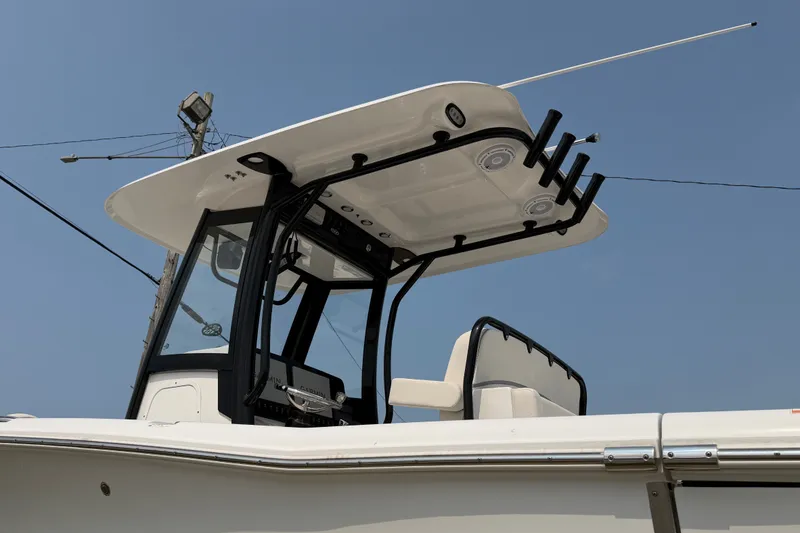 Slide: The Image of 2024 Sea Hunt Ultra 275 SE boat with T-top and rod holders against clear sky. - 5