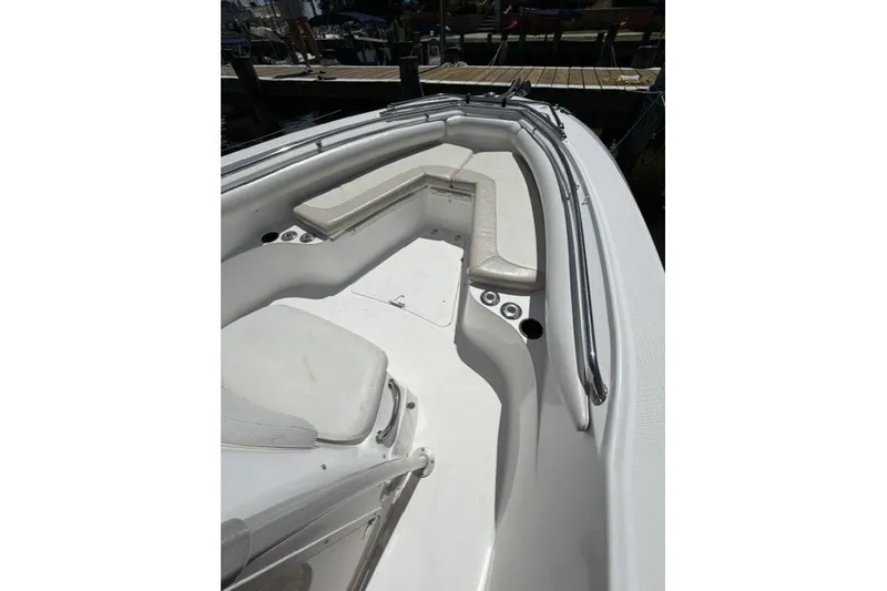 Slide: The Image of 2004 Boston Whaler 270 Outrage boat interior with cushioned seating and stainless steel railings. - 3