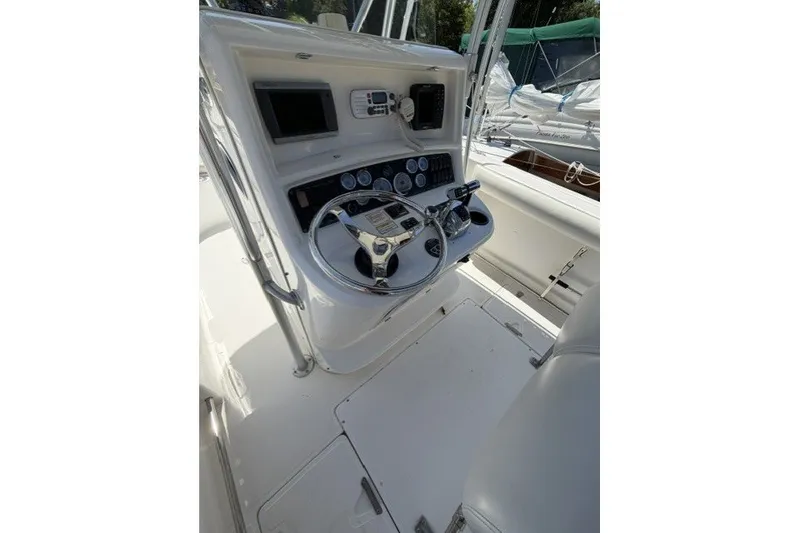 Slide: The Image of 2004 Boston Whaler 270 Outrage helm with steering wheel and control panel. - 12