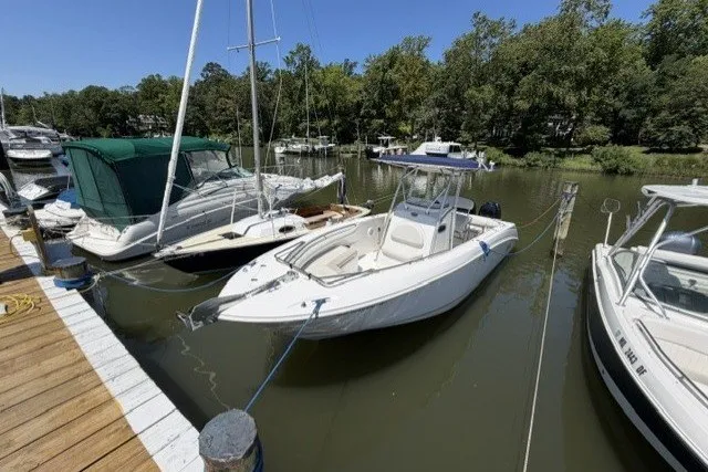 The Image of 2004 Boston Whaler 270 Outrage docked in a serene marina setting. - 0