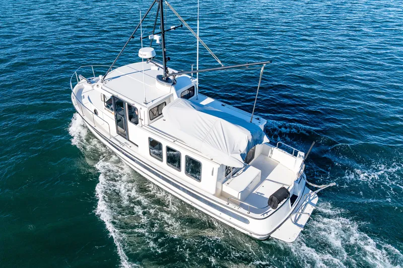 Slide: The Image of Nordic Tug 32, 2000 model, cruising on open water, aerial view. - 5