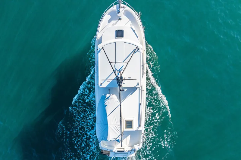 Slide: The Image of Aerial view of 2000 Nordic Tug 32 cruising on clear blue water. - 9