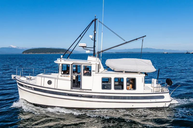 Slide: The Image of 2000 Nordic Tug 32 cruising on open water under clear blue skies. - 4