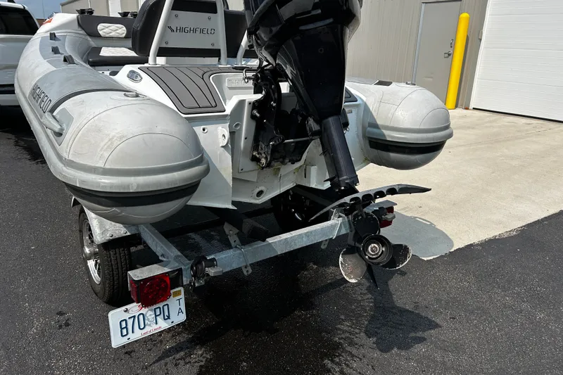 Slide: The Image of 2021 Highfield Sport 330 boat on trailer, featuring outboard motor and license plate. - 5