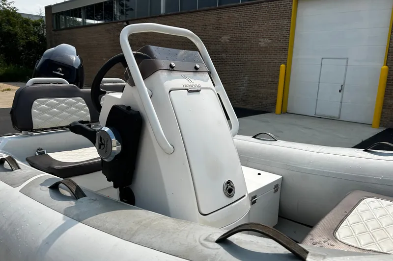 Slide: The Image of 2021 Highfield Sport 330 boat interior with steering console and seating. - 12