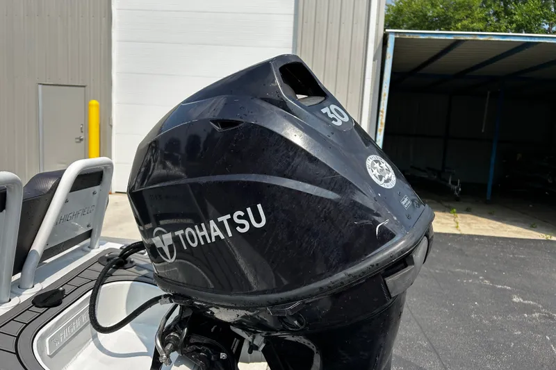 Slide: The Image of 2021 Highfield Sport 330 with Tohatsu 30HP outboard motor in a garage setting. - 4
