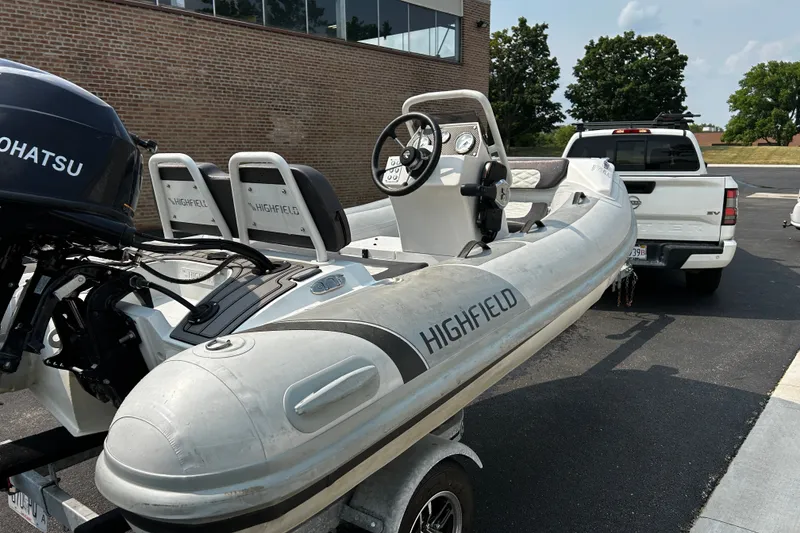 Slide: The Image of 2021 Highfield Sport 330 inflatable boat on trailer, parked near a white truck. - 7