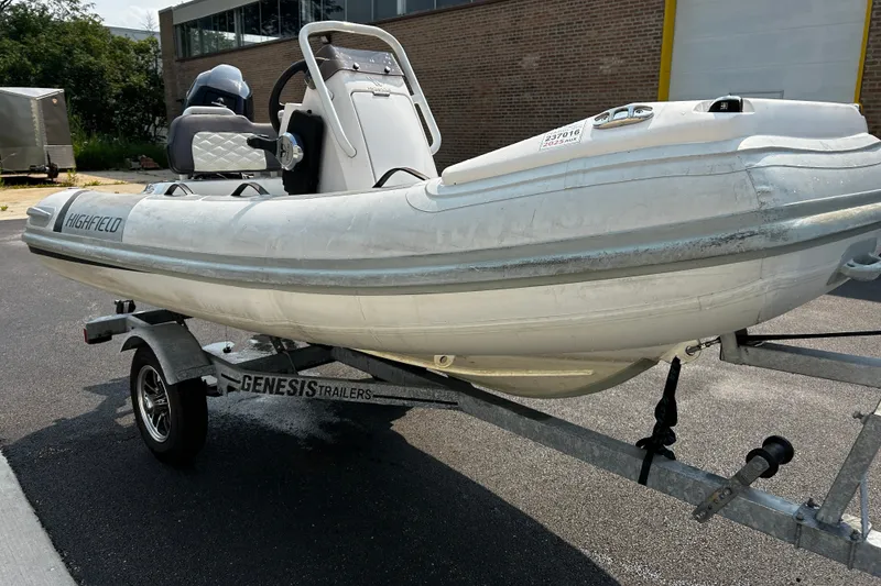 Slide: The Image of 2021 Highfield Sport 330 inflatable boat on Genesis trailer, parked outdoors. - 14