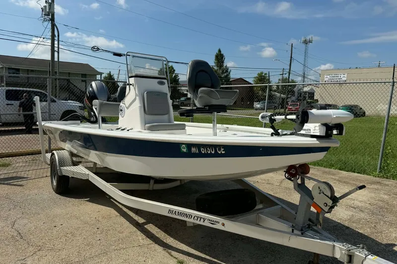 Slide: The Image of 2021 Avid 19 FS boat on trailer, parked outdoors under clear sky. - 2