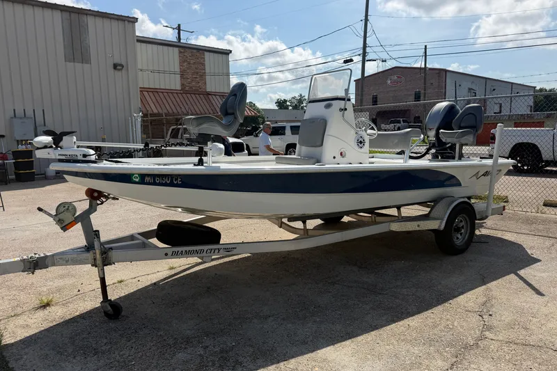 Slide: The Image of 2021 Avid 19 FS boat on trailer, parked outdoors under a clear sky. - 1