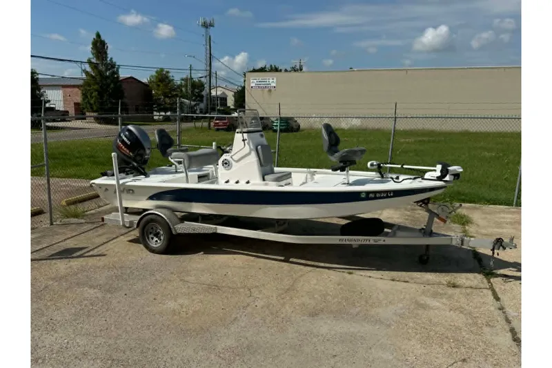 The Image of 2021 Avid 19 FS boat on trailer, parked outdoors under clear sky. - 0