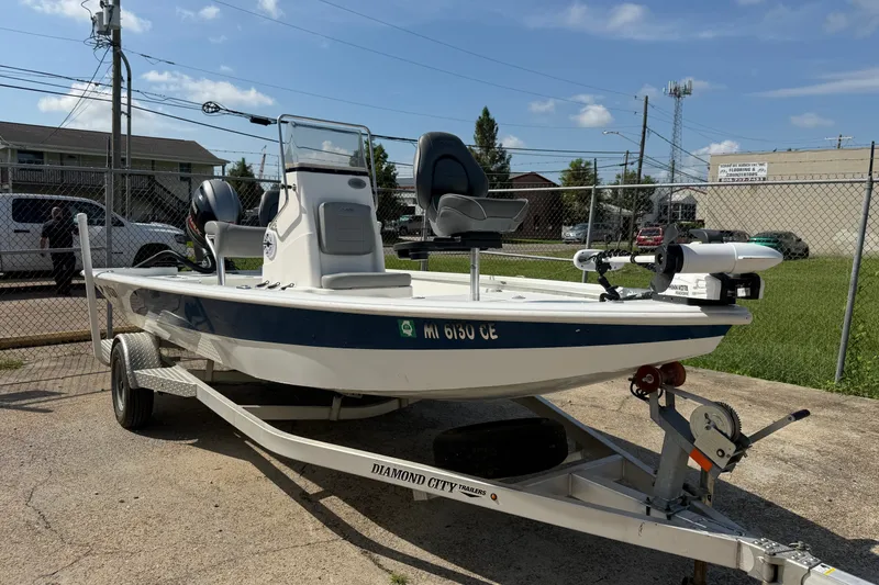 Slide: The Image of 2021 Avid 19 FS boat on trailer, parked outdoors under a clear sky. - 16
