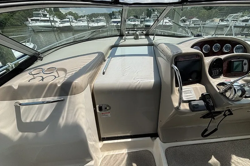 Slide: The Image of 2006 Sea Ray 340 Sundancer cockpit with steering wheel, gauges, and marina view. - 18