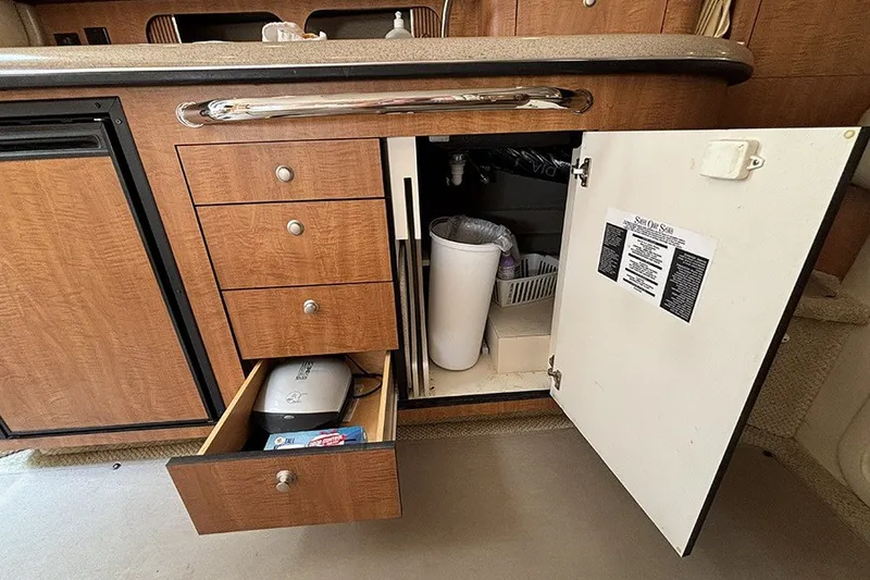 Slide: The Image of 2006 Sea Ray 340 Sundancer kitchen cabinet with open drawers and storage space. - 27