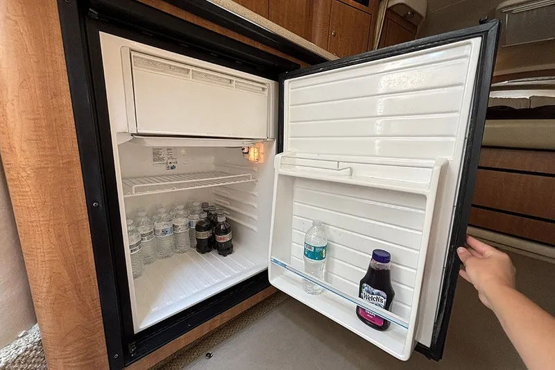 Slide: The Image of Mini fridge stocked with drinks inside a 2006 Sea Ray 340 Sundancer boat cabin. - 26