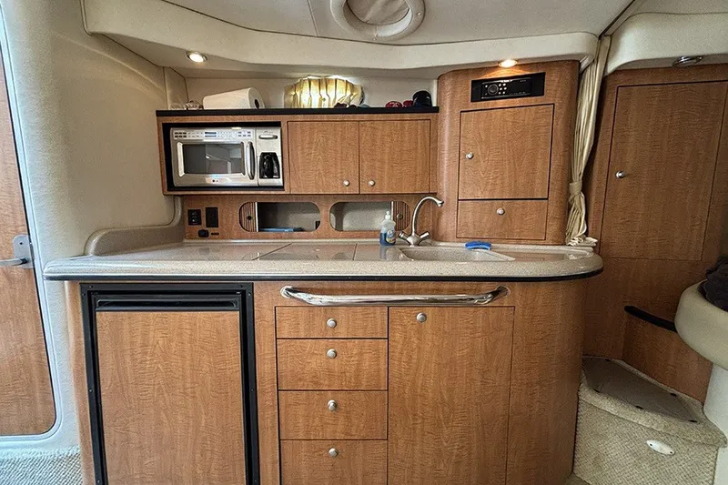 Slide: The Image of 2006 Sea Ray 340 Sundancer yacht interior kitchen with wood cabinetry and appliances. - 22