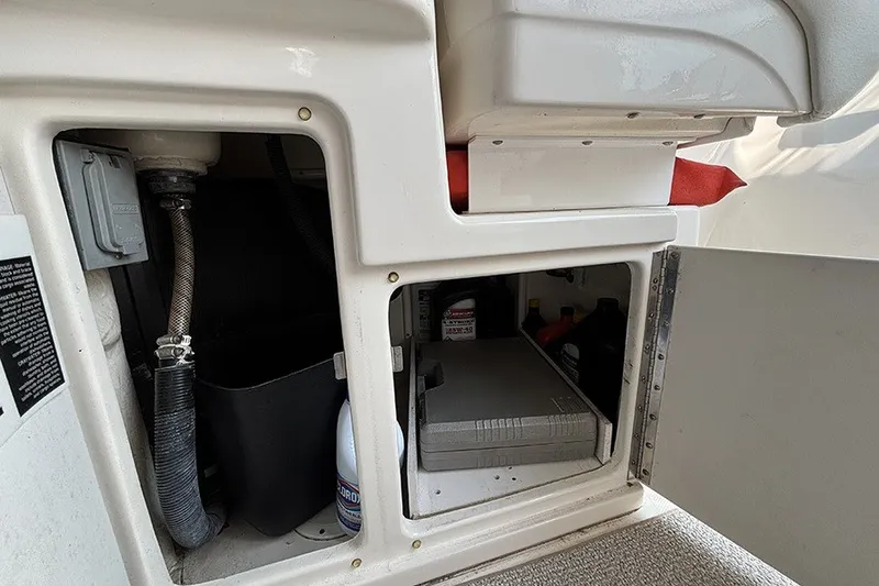 Slide: The Image of Storage compartment of a 2006 Sea Ray 340 Sundancer boat, showing maintenance supplies. - 12
