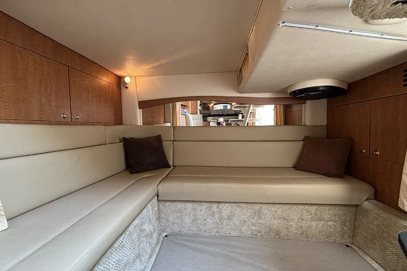 Slide: The Image of 2006 Sea Ray 340 Sundancer cabin interior with beige seating and wooden cabinetry. - 34