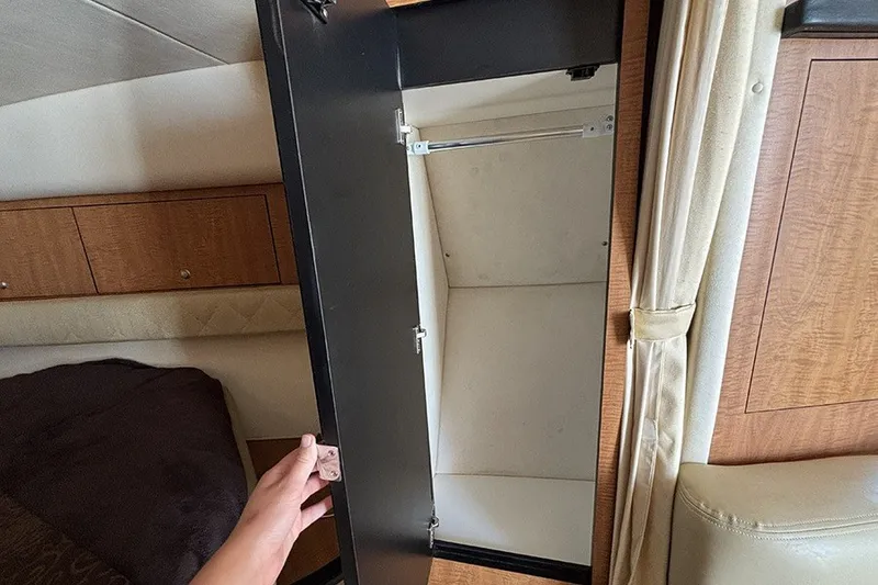 Slide: The Image of Open cabinet inside 2006 Sea Ray 340 Sundancer boat, showcasing interior storage space. - 23