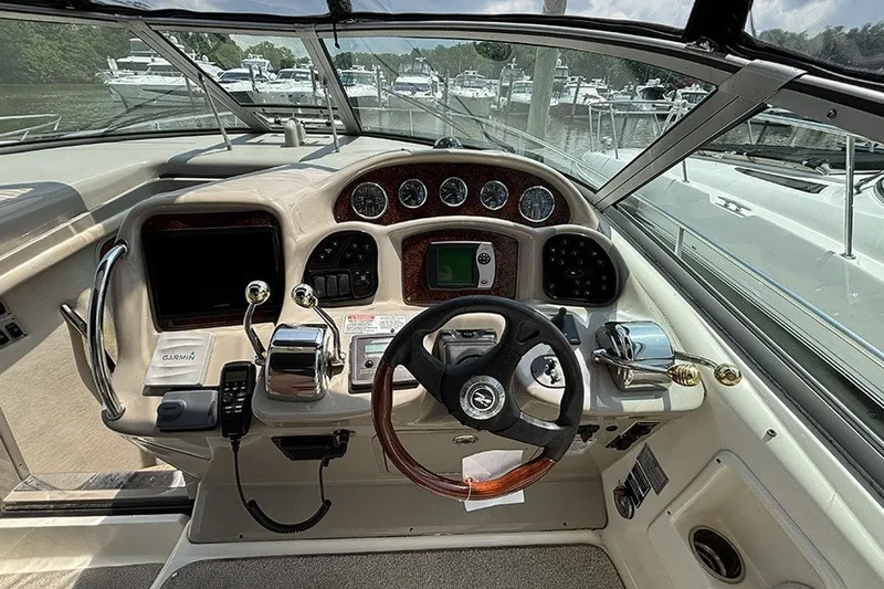 Slide: The Image of 2006 Sea Ray 340 Sundancer helm with steering wheel and navigation controls. - 15