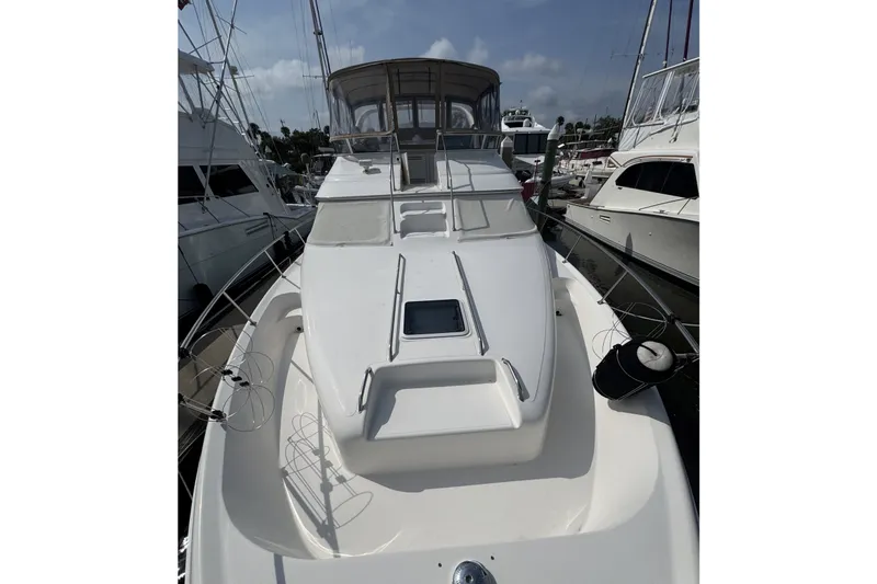 Slide: The Image of 2001 Sea Ray 450 Express Bridge yacht docked at marina, showcasing sleek design and spacious deck. - 4