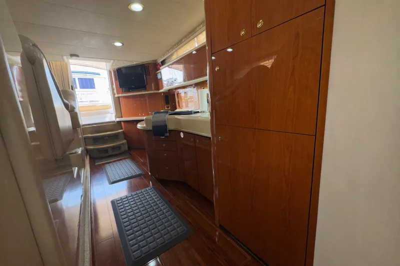 Slide: The Image of Interior of 2001 Sea Ray 450 Express Bridge with wood cabinetry and modern amenities. - 22