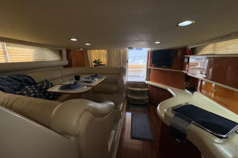 Slide: The Image of Luxurious interior of 2001 Sea Ray 450 Express Bridge yacht with elegant seating and dining area. - 15