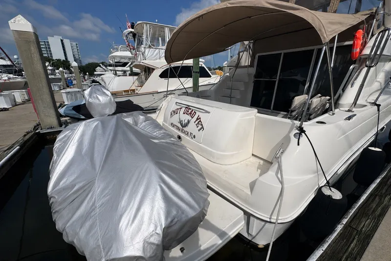 Slide: The Image of 2001 Sea Ray 450 Express Bridge docked at marina, covered equipment visible. - 3