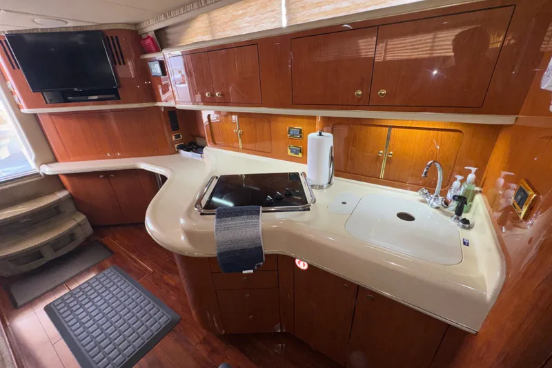 Slide: The Image of Luxurious 2001 Sea Ray 450 Express Bridge yacht kitchen with modern amenities and wood cabinetry. - 19