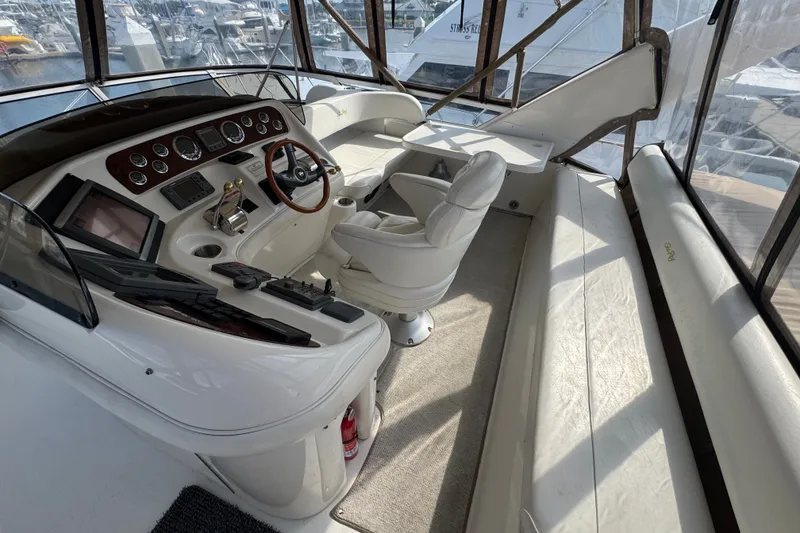 Slide: The Image of 2001 Sea Ray 450 Express Bridge helm with luxurious seating and modern controls. - 10