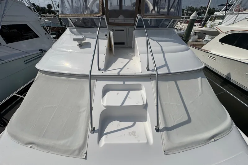Slide: The Image of 2001 Sea Ray 450 Express Bridge yacht docked at marina, showcasing spacious deck. - 5