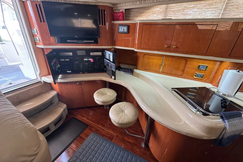 Slide: The Image of Interior of 2001 Sea Ray 450 Express Bridge with wood cabinetry and modern amenities. - 17