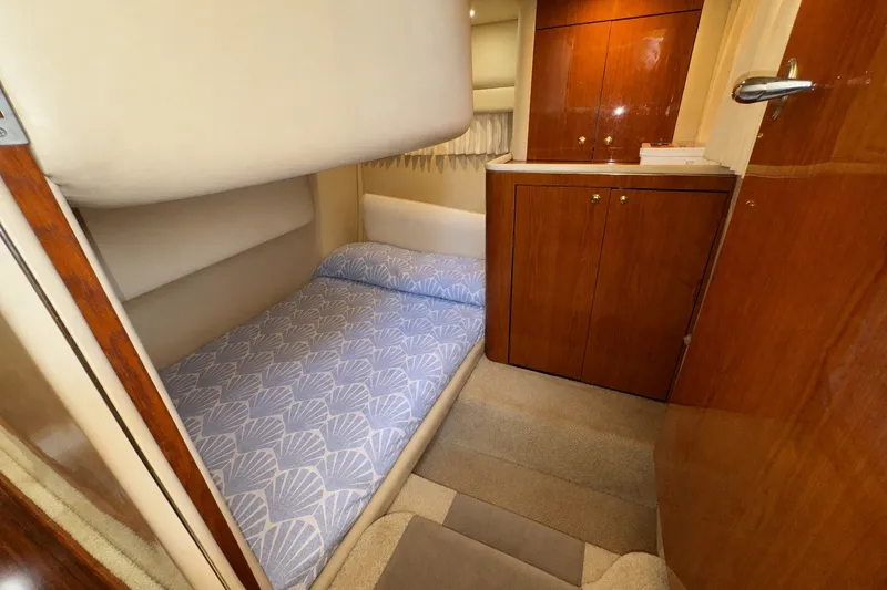 Slide: The Image of Interior cabin of 2001 Sea Ray 450 Express Bridge with cozy bed and wooden cabinetry. - 28