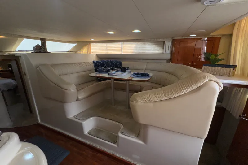 Slide: The Image of Luxurious interior of 2001 Sea Ray 450 Express Bridge yacht with plush seating and dining area. - 21