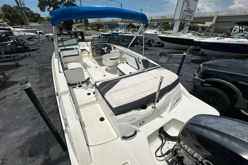 Slide: The Image of 2016 Sea Ray SPX 210 Outboard boat with blue canopy in a marina setting. - 15