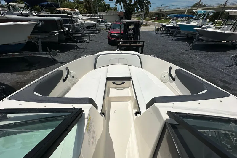 Slide: The Image of 2016 Sea Ray SPX 210 Outboard boat interior with seating, parked among other boats. - 6