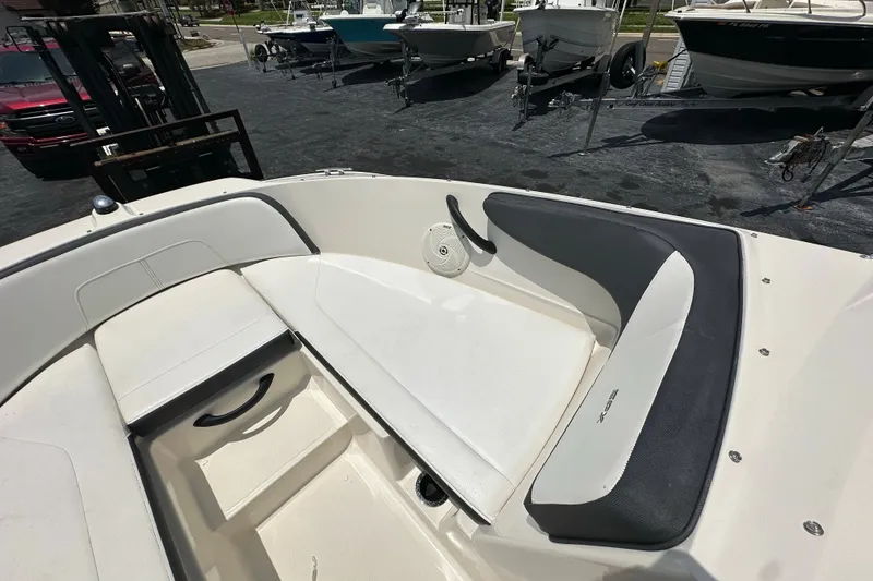 Slide: The Image of 2016 Sea Ray SPX 210 Outboard boat interior with cushioned seating and storage. - 7