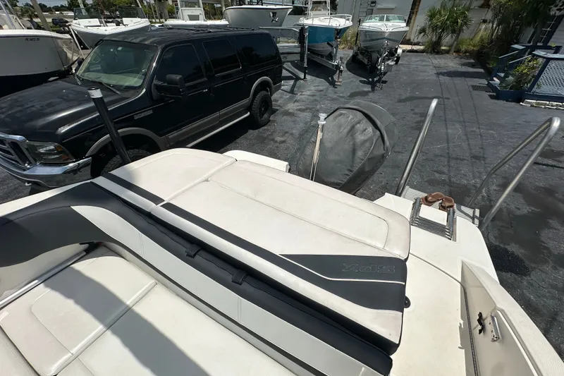 Slide: The Image of 2016 Sea Ray SPX 210 Outboard boat with seating, parked near a black SUV. - 13