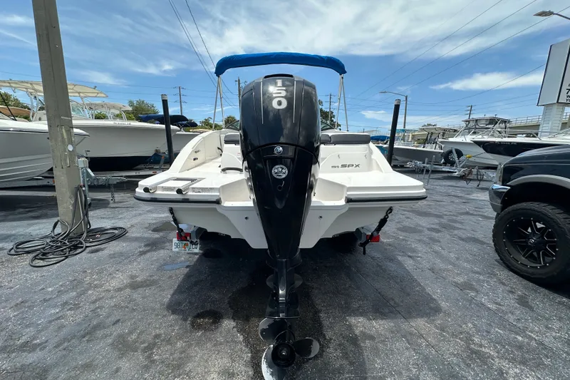 Slide: The Image of 2016 Sea Ray SPX 210 Outboard boat with 150 HP engine, parked outdoors. - 3