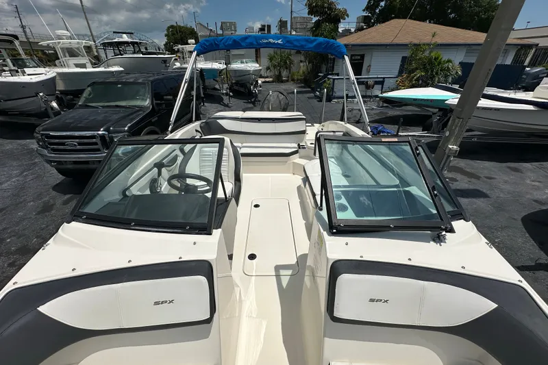 Slide: The Image of 2016 Sea Ray SPX 210 Outboard boat with open deck and windshield, docked at marina. - 9