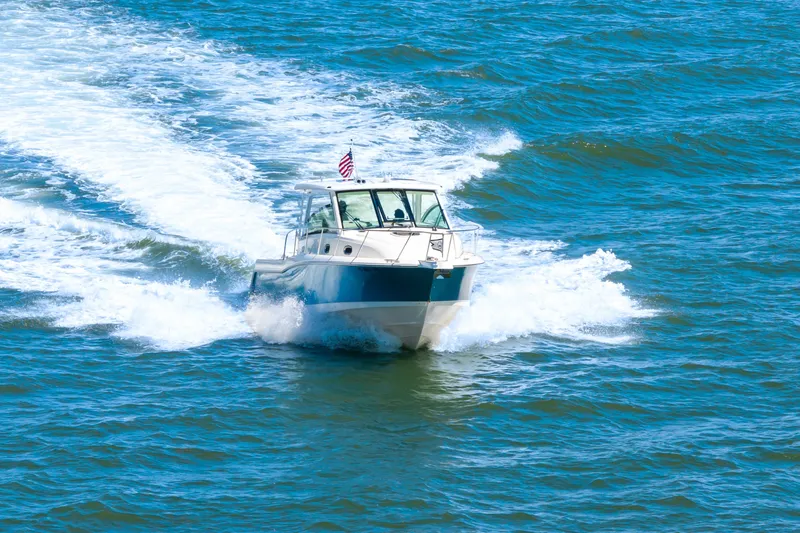 Slide: The Image of 2018 Boston Whaler 345 Conquest cruising on open water with American flag. - 15