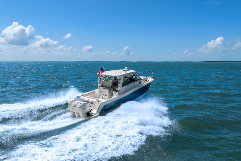 Slide: The Image of 2018 Boston Whaler 345 Conquest cruising on open ocean under clear blue sky. - 17