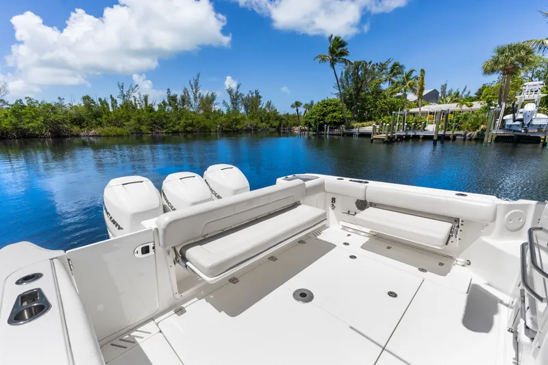 Slide: The Image of 2018 Boston Whaler 345 Conquest boat with triple engines on a serene waterway. - 26