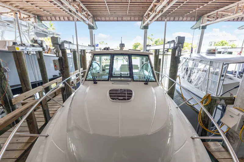 Slide: The Image of 2018 Boston Whaler 345 Conquest docked in a marina under a wooden roof. - 49