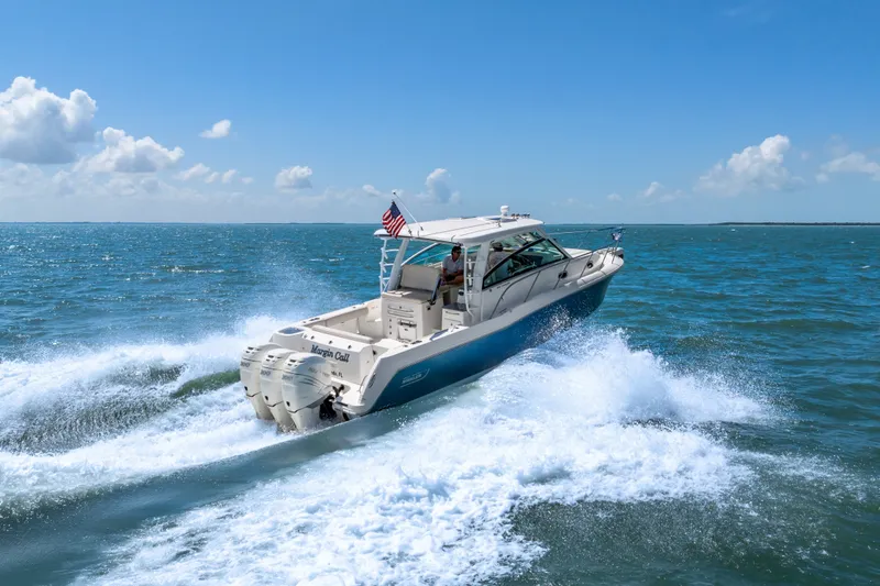 Slide: The Image of 2018 Boston Whaler 345 Conquest cruising on open water under a clear blue sky. - 4