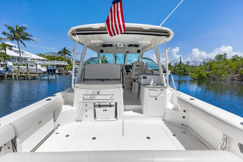 Slide: The Image of 2018 Boston Whaler 345 Conquest boat docked, featuring spacious deck and American flag. - 21