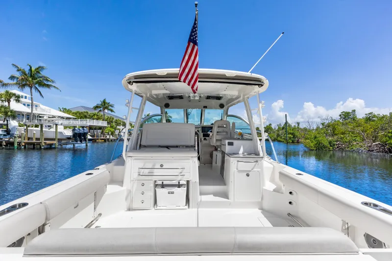 Slide: The Image of 2018 Boston Whaler 345 Conquest boat docked, featuring spacious deck and American flag. - 20