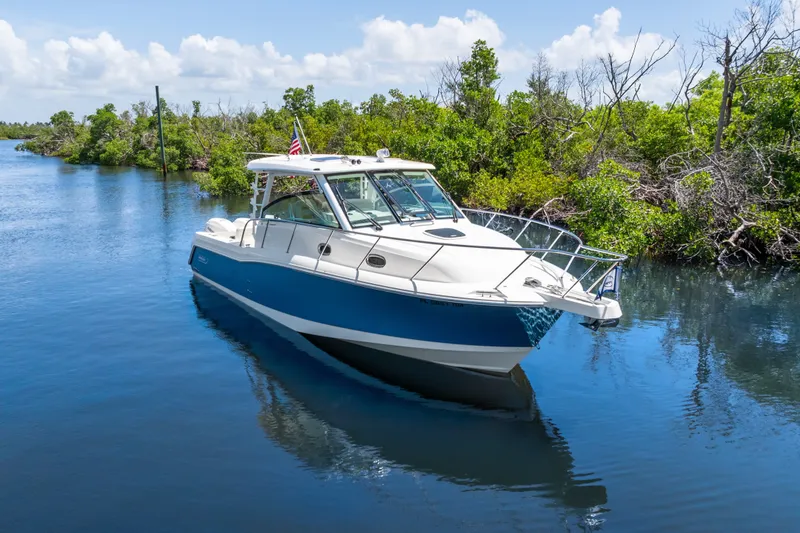 Slide: The Image of 2018 Boston Whaler 345 Conquest boat cruising on a serene waterway. - 9