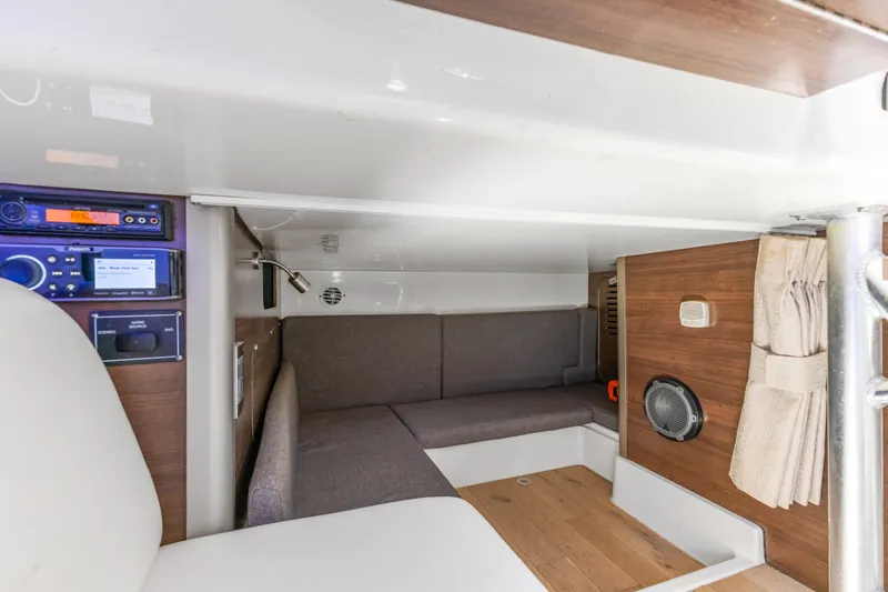Slide: The Image of 2018 Boston Whaler 345 Conquest cabin interior with seating, audio system, and wood accents. - 38